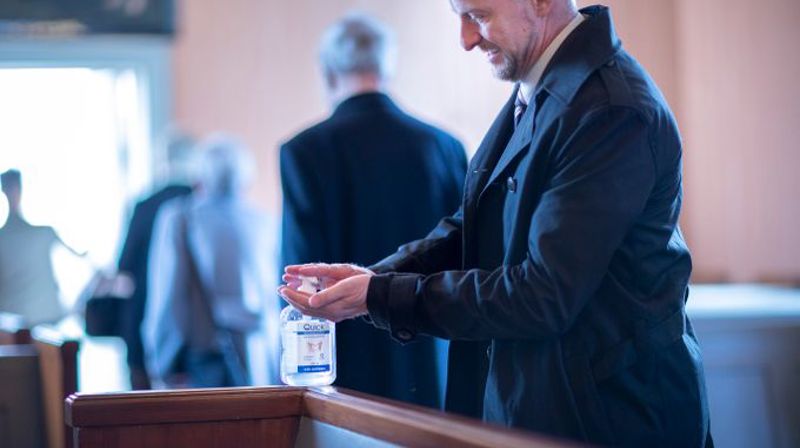 Fra dåp i Fenstad kirke i koronatiden, håndsprit står utplassert i kirkebenken. Foto: Bo Mathisen.