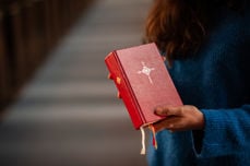 Kirkevert deler ut salmebok før gudstjeneste. Foto: Kirkerådet