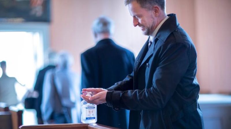 Fra dåp i Fenstad kirke i koronatiden, håndsprit står utplassert i kirkebenken. Foto: Bo Mathisen.