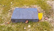 Bilde av nedlagt gravstein med gult merke