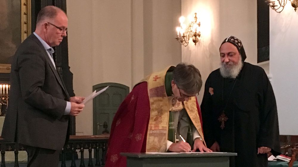 Biskop Stein Reinertsen undertegner avtalen i Domkirken