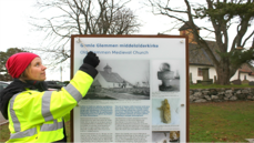 Arkeolog Jone Kile-Vesik monterer nytt informasjonsskilt ved Gamle Glemmen kirke i Fredrikstad, foto: Silje Haugsten Ellefsen