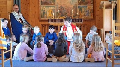 Sokneprest Benjamin Fjellheim Olsen samlar ungane i Sødorp kapell under gudstenesta den siste visitasdagen. Foto: Venke Sletten