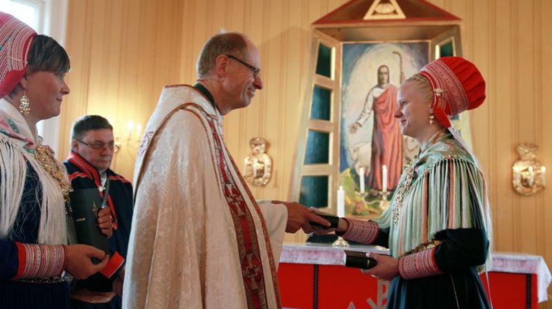 Elle Karen Inga Skum overrekker Bibelen til biskop Olav Øygard . Foto: Johan Mathis Gaup