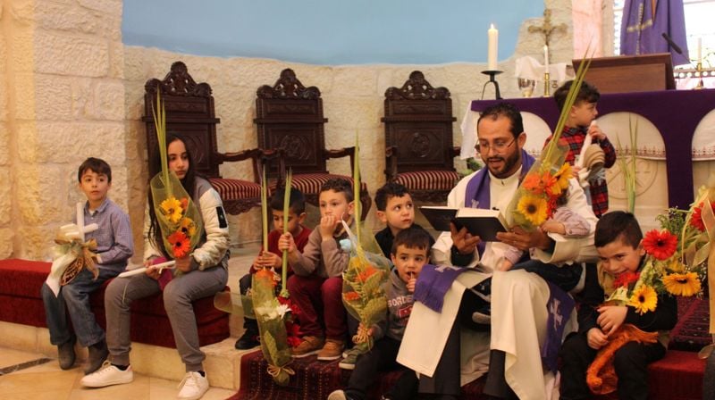 Sokneprest Ashraf Tannous, med barn i kirken i Beit Jala (fra deres hjemmeside)