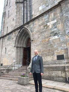 Menighetsrådsleder Christian Nesset foran Domkirken hvor fraværet av stillas vitner om fremgang i arbeidet med å renovere kirken. (Foto:Eirik B. Minde)