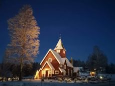 Moen kirke i nysnø og med juletreet tent, desember 2021. (Foto: Ruth Kari Sørumshagen). 