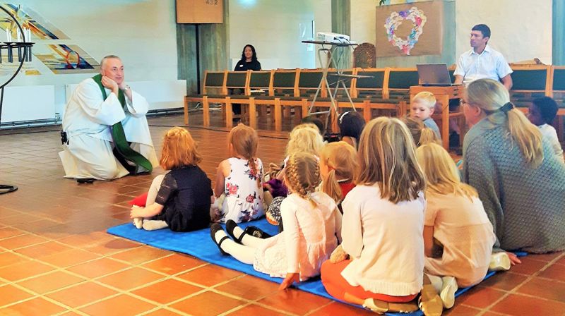 I Rossabø kirke har prest Bård Egil Dyrhold satt seg på gulvet for å fortelle om Martha og Maria til barna.