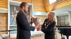 Ordfører Birgitta Gulla Løken overrekker blomster til konstituert kirkeverge Jan Einar Bjerke Hals.