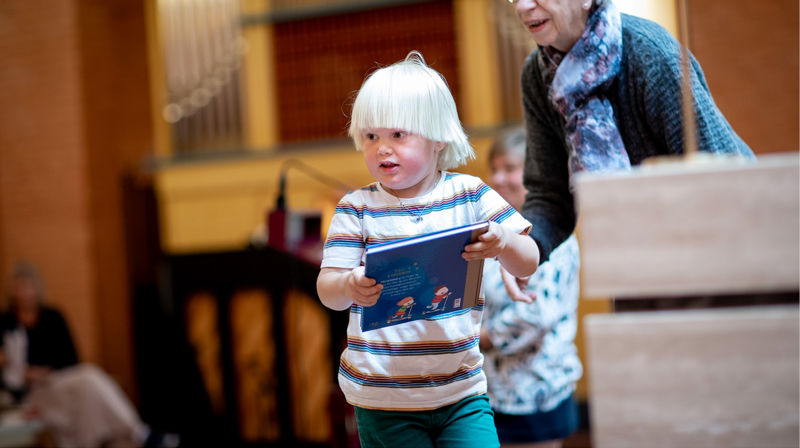 4-åring går med 4-årsbok i hendene. Foto: Bo Mathisen