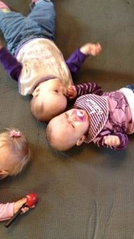 Tre babyer på matte på gulvet