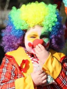 Bilde av et barn utkledd som klovn med fargerik parykk