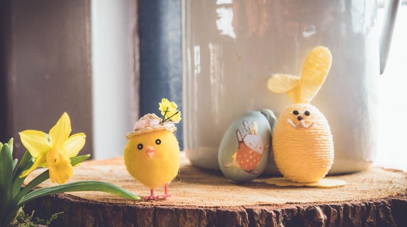 En påskelilje og to gule påskeegg en pyntet som kylling, en som påskehare.
