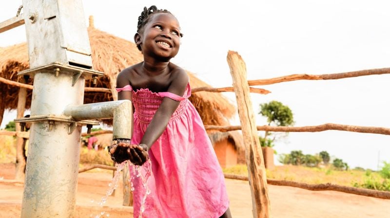 Champo 5 år drikker rent vann fra vannpumpen i nærheten av hjemmet deres. Hør mer om henne i filmen nederst på siden. Foto: Jason Mulikita/Fairpictures.
