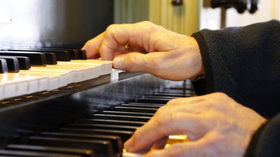 To hender spiller på et orgel, høyre hånd på den øverste klaviaturen og venstre på den nederste