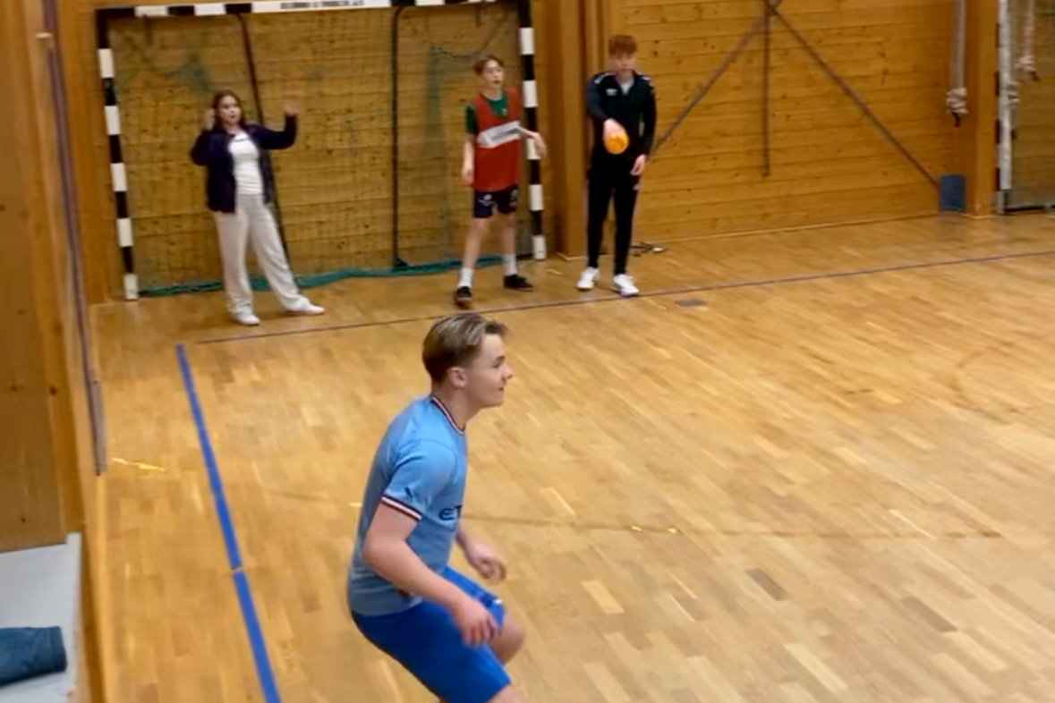 Ungdommer spiller ballspill inne i en gymsal