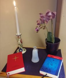 Bord med tent lys, bibel og salmebok