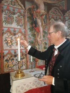 Kirketjener Knut tenner alterlysene